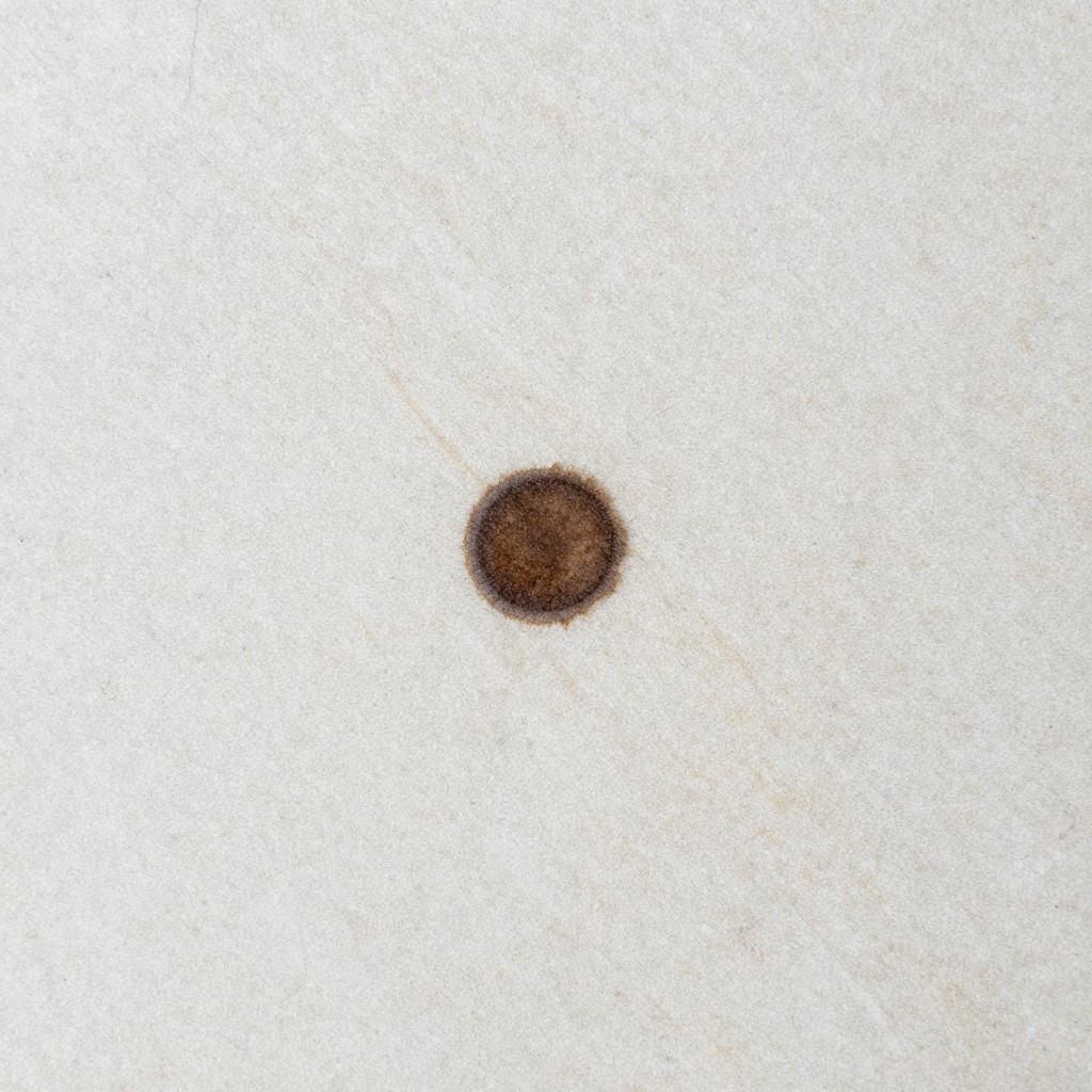 Synthetic limestone tabletop with a central brown stain